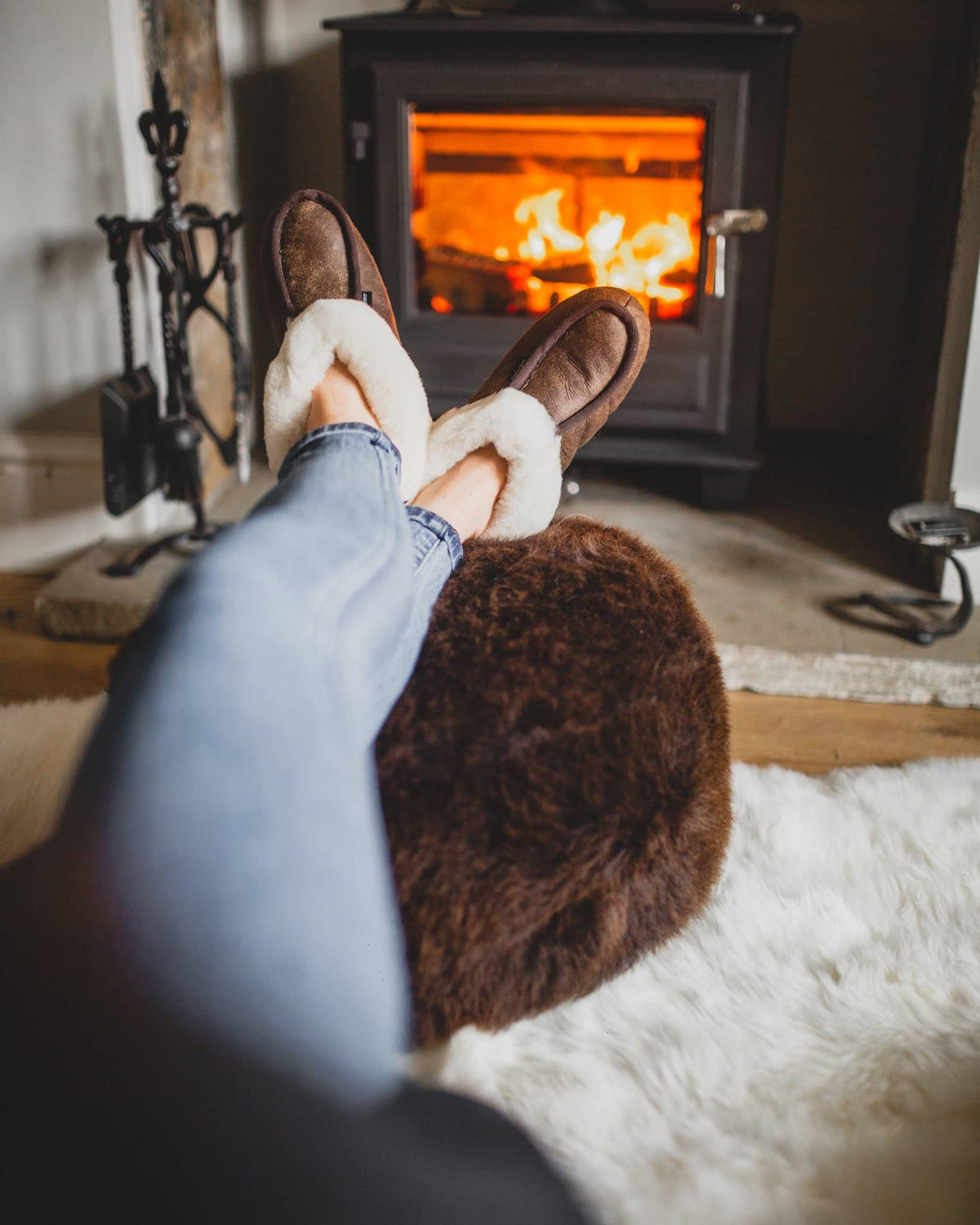Shepherd womens sheepskin slippers MOA oiled antique model wearing in front of fire