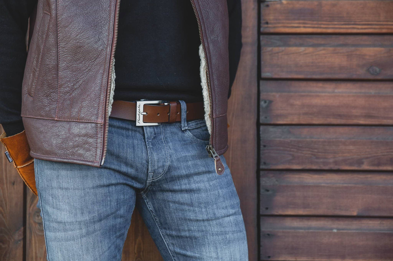 Close up of man wearing Hawkdale brown 811-400 full grain leather belt with stables background
