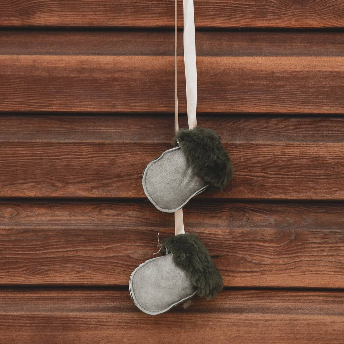 Kids Nordvek sheepskin puddy mittens 303-100 black leather with cream ribbon hanging on stables