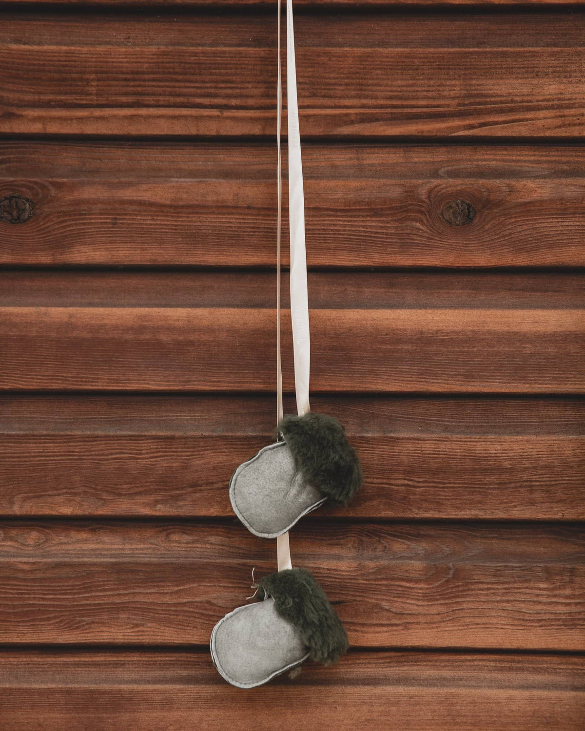 Kids Nordvek sheepskin puddy mittens 303-100 hunter green with cream ribbon hanging on stables