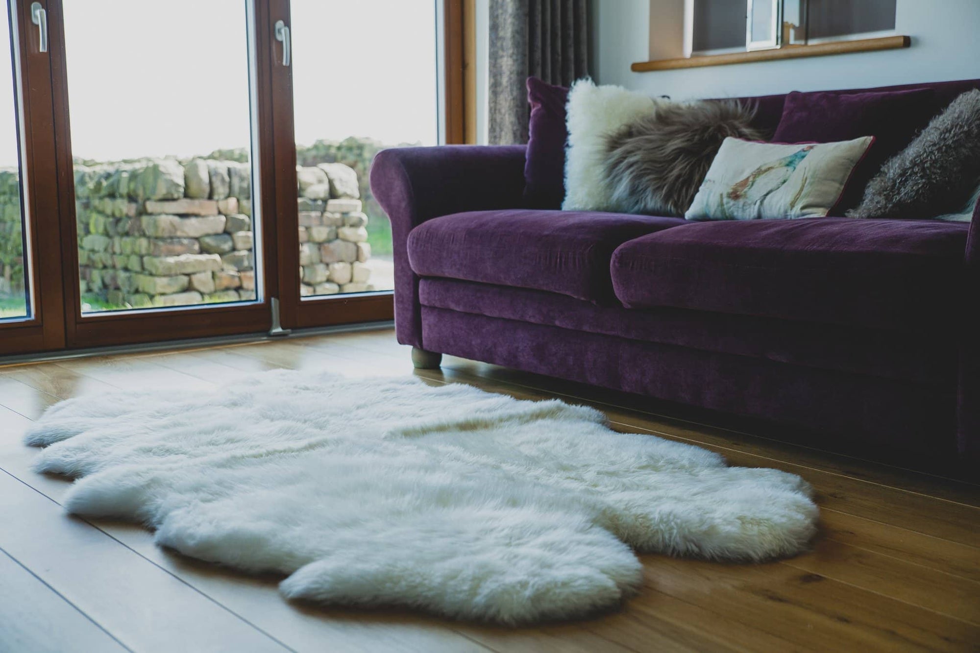 Nordvek sheepskin  natural rug 604-100 quad in front of sofa close up