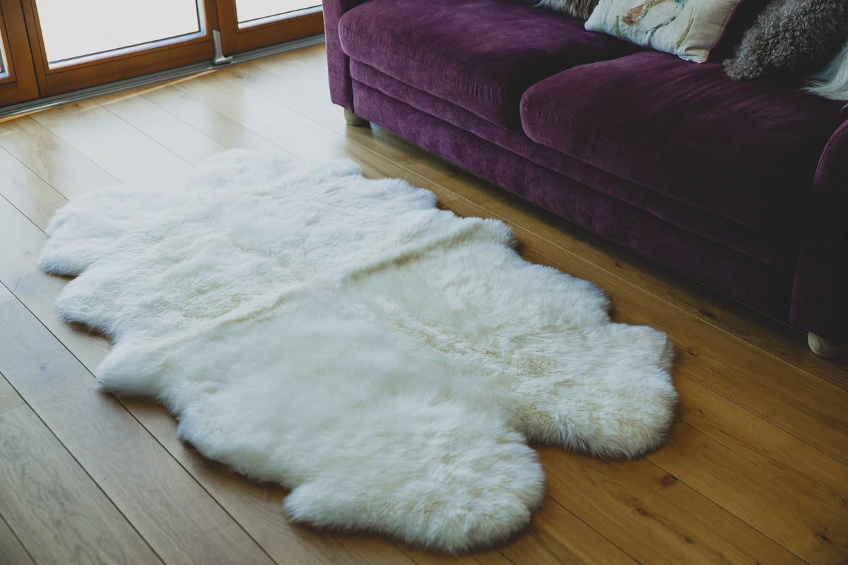Nordvek sheepskin  natural rug 604-100 quad in front of sofa close up