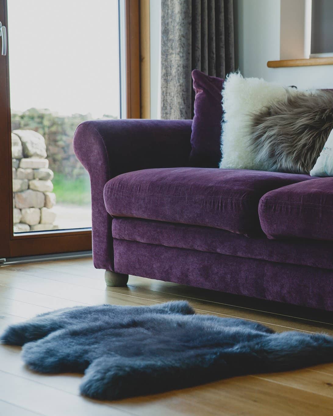 Nordvek sheepskin rug coloured grey in front of fire