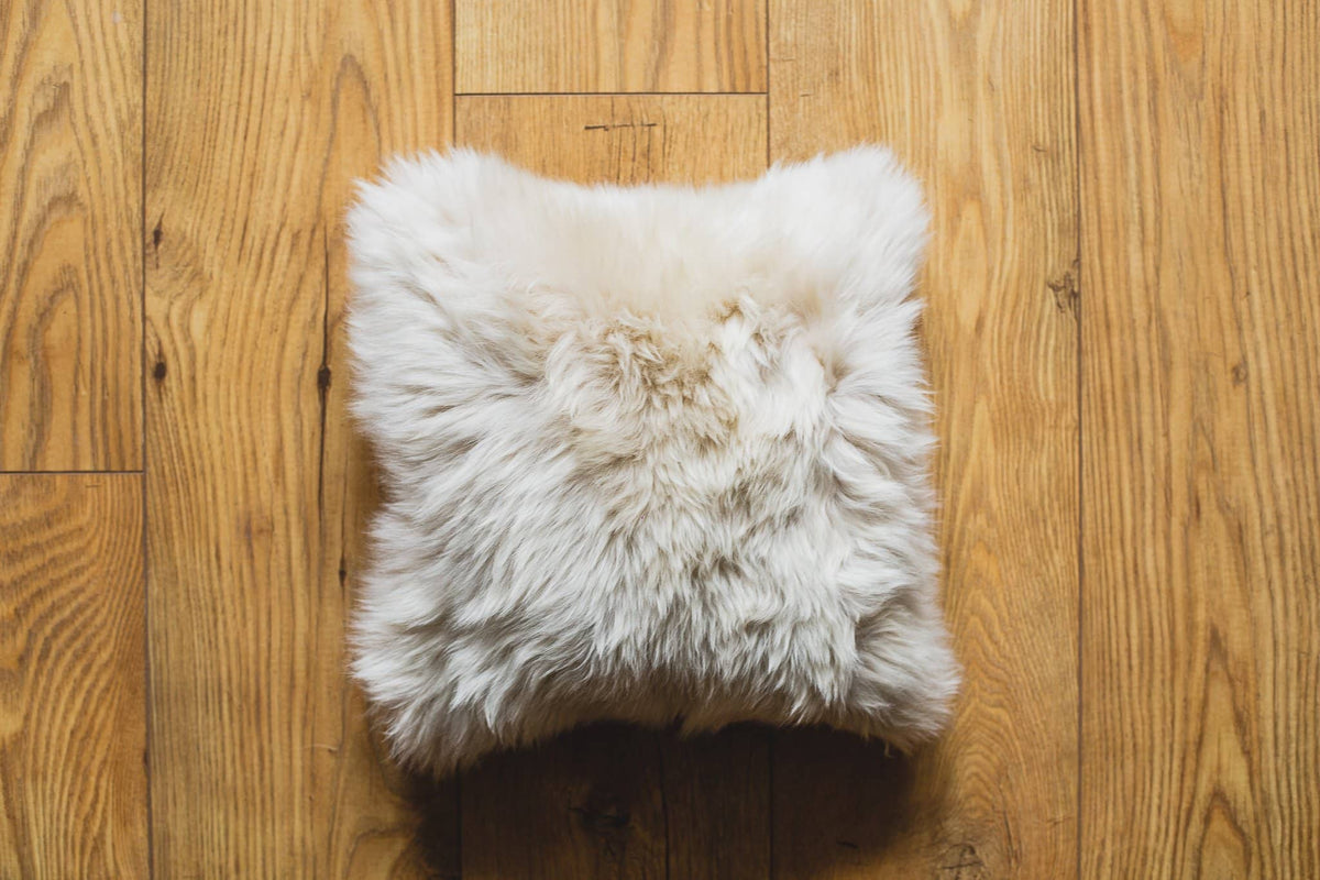 Nordvek sheepskin cushion 9001-100 beige on wooden floor