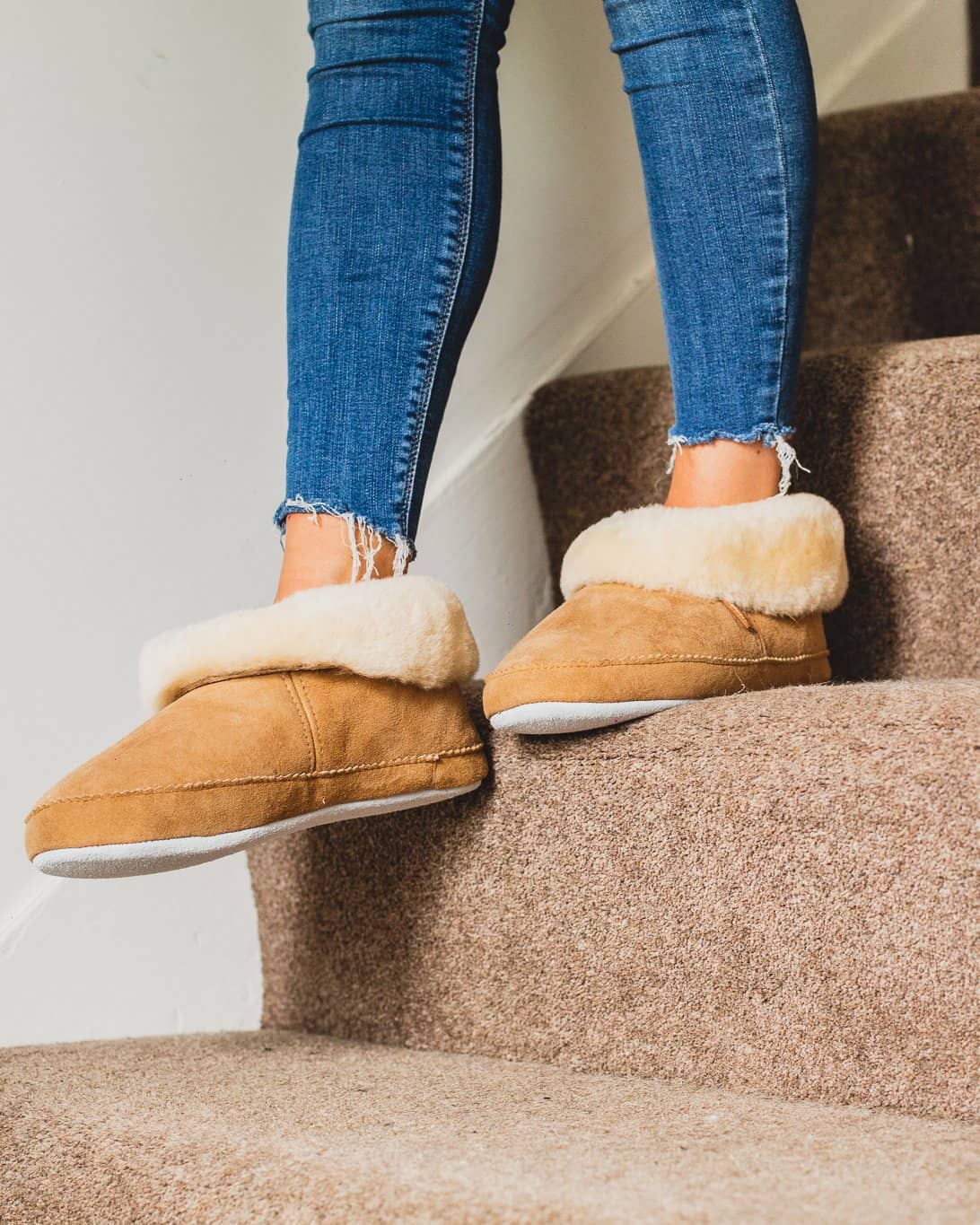 Shepherd womens sheepskin slippers EMMY chestnut model wearing pair in front of fire